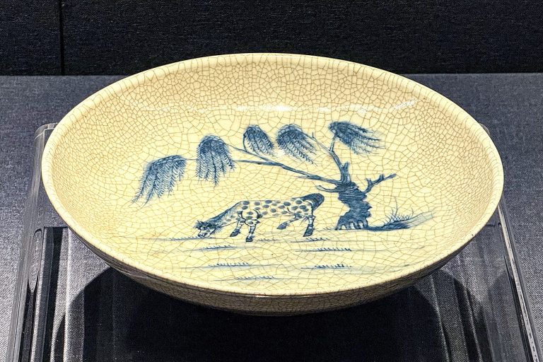 Blue-and-white plate painted with a willow tree and a horse